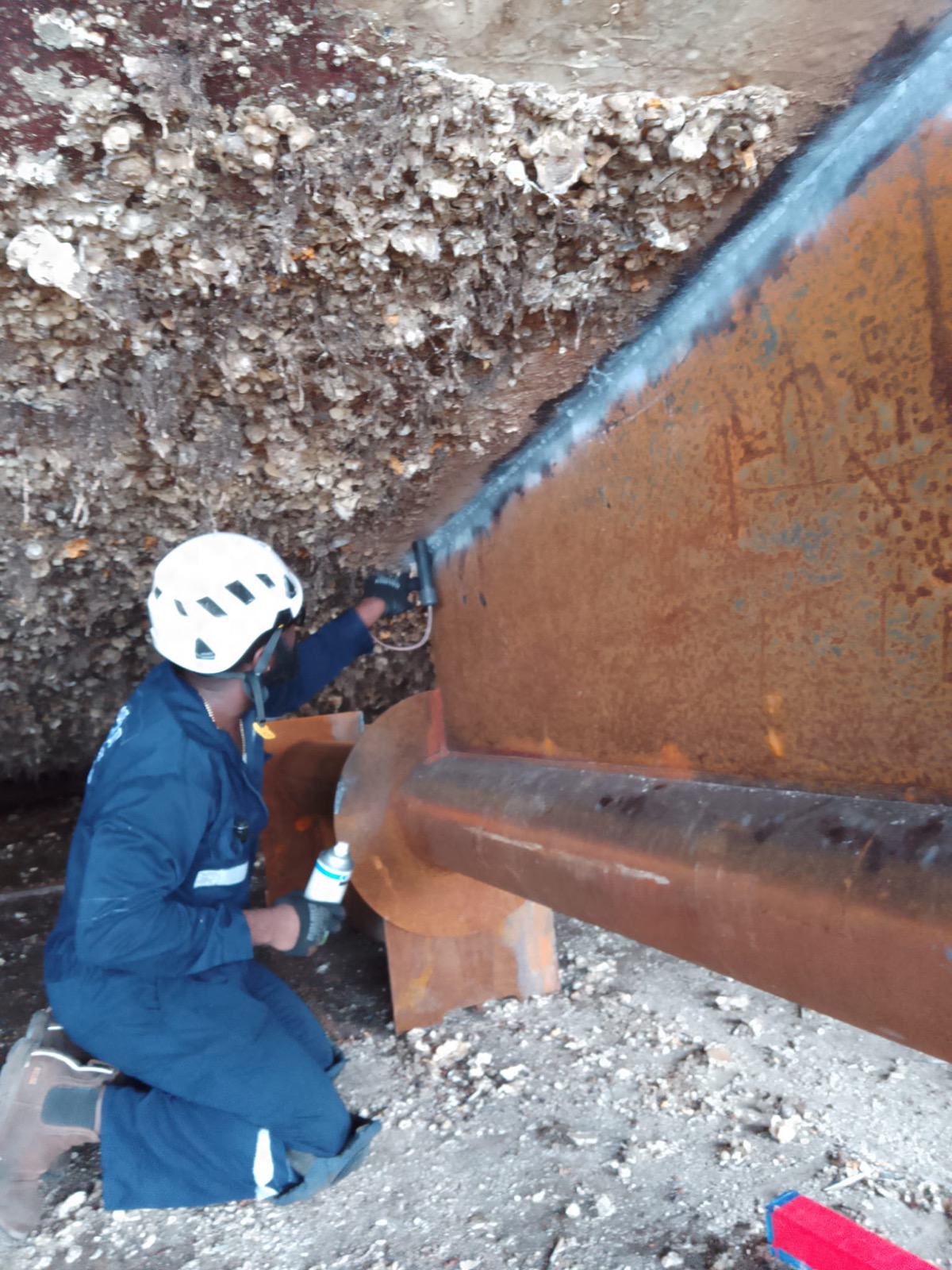 OEM technician inspecting a vessel hull in dry dock